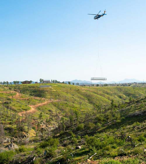 A helicopter in action caring a bridge over Salt Creek